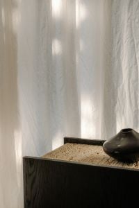 Kaboompics - Black Sideboard and Ceramic Vase with Soft Curtain Light