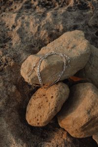 Kaboompics - Silver Chain Necklace Curved Around a Weathered Stone