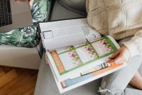 Kaboompics - The woman is reading the newspaper while sitting on the couch in the house