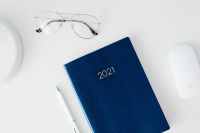 Kaboompics - Navy 2021 Planner, Eyeglasses and White Mouse on Desk