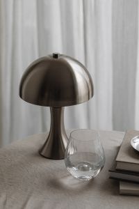 Kaboompics - Chrome Dome Lamp and Glass on Neutral Fabric-Covered Table