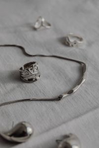Kaboompics - Silver Chain, Rings and Jewelry on White Tablecloth