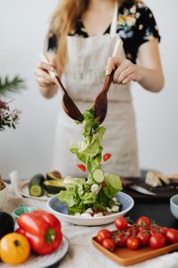 Young Woman Preparing Fresh Salad and Healthy Meals in a Home Kitchen