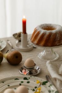 Kaboompics - Easter Table with Bundt Cake Red Candle and Egg Cup