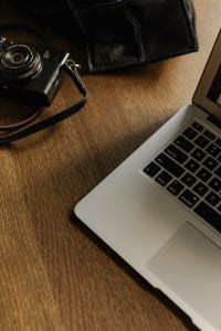 Kaboompics - Camera, Leather Bag and Laptop on Wooden Home Office Desk