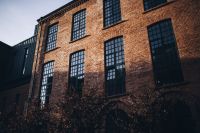 Kaboompics - Brick Loft Facade Framed by Dark Autumn Foliage