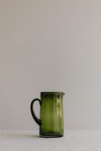 Kaboompics - Green Glass Pitcher with Copy Space on a Neutral Table