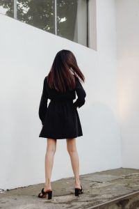 Kaboompics - Woman from Behind in Black Dress with Long Hair and White Wall Background