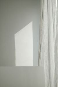 Kaboompics - Geometric Sunlight and Sheer Curtain Shadows on Neutral Wall
