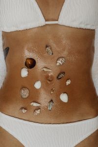 Kaboompics - Seashells on a Tanned Abdomen in a White Bikini