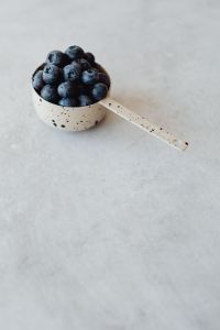 Kaboompics - Wooden Scoop of Blueberries on Gray Surface