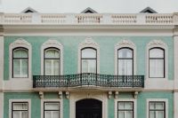 Kaboompics - Mint Green Lisbon Facade with Carved Window Pediments and Curved Iron Balcony