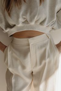 Kaboompics - Woman Adjusting a White Sweatshirt in a Minimalist Outfit