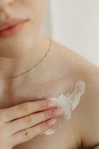 Kaboompics - Hand Rubbing Moisturizing Cream into the Shoulder During Body Care