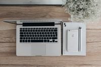 Kaboompics - Silver Acer laptop on a wooden desk with a green plant, pencils and an Apple iPhone