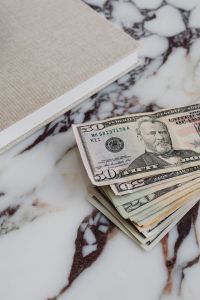 Kaboompics - Dollar Bills and Linen Placemat on White Marble Background
