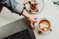 Kaboompics - Working with a laptop, meringue with whipped cream and coffee on white marble