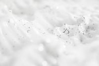 Kaboompics - White Skincare Cream Peaks with Sparse Dark Speckles, Minimal Macro Texture Background
