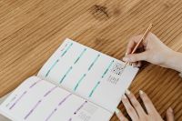 Kaboompics - Open Weekly Bullet Journal With Hand and Gold Pen