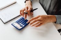 Kaboompics - Hands Using a Calculator Beside a Notebook