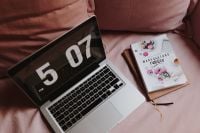 Kaboompics - Laptop and Floral-Cover Book on a Pink Sofa