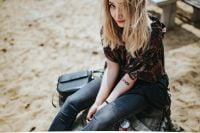 Kaboompics - Woman Sitting on a Beach Tree Stump with Cola Can and Shoulder Bag
