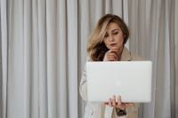 Kaboompics - Businesswoman Looking Down at Her Laptop with Hand on Chin