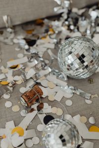 Kaboompics - Close-Up Disco Ball and New Year's Eve Confetti on Gray Upholstery
