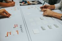 Kaboompics - Brainstorming Board with Sticky Notes and Hands Arranging Ideas