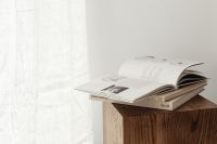 Kaboompics - Open Book Stack on Walnut Side Table in Neutral Interior