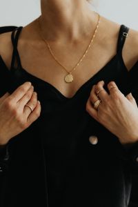 Gold Jewelry Fashion Photography with Rings, Necklace and Woman in Black