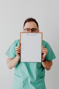 Kaboompics - Doctor Holding Blank Clipboard Toward Camera