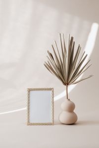 Kaboompics - Minimalist Gold Frame and Dried Palm Vase Against a Soft Beige Wall, Copy Space