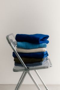 Kaboompics - Winter Knitwear Stack on Transparent Chair for Capsule Wardrobe