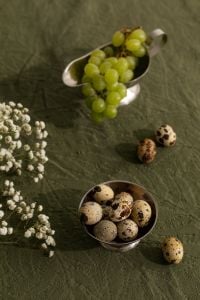 Kaboompics - Green Grapes, Quail Eggs and Baby's Breath on Textured Green Linen
