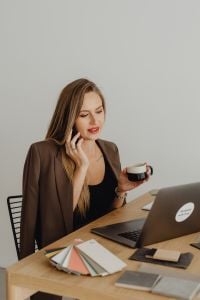Kaboompics - Woman Talking on Phone Beside Laptop and Coffee