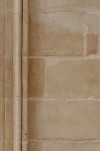 Kaboompics - Beige Stone Wall Texture beside Ornate Paneled Door