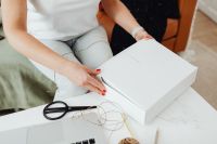 Kaboompics - Hands Folding a White Mailer Box to Prepare Small Business Orders for Shipping