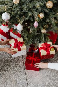 Kaboompics - Hands Arranging Wrapped Gifts Under a Christmas Tree