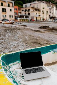 Kaboompics - Overhead MacBook in a Yellow Dinghy on a Pebble Beach