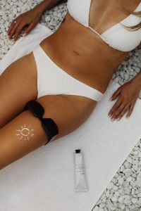 Kaboompics - Sun Body Paint, Sunglasses and Sunscreen on a White Beach Towel