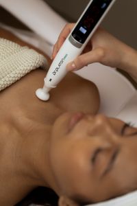 Kaboompics - Handheld Facial Device Applied to Collarbone
