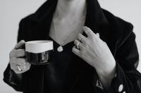 Kaboompics - Woman Holding Coffee Cup in Black Blazer with Gold Necklace