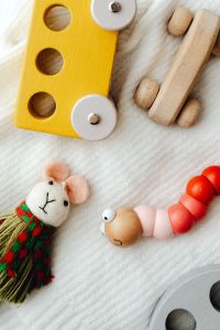 Kaboompics - Wooden Puzzle Toys and Handmade Mouse Doll on a Soft Cotton Blanket
