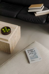 Kaboompics - Beige Sofa with Art Book, Black Leather Sofa and Travertine Table