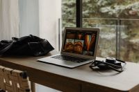 Kaboompics - Home Office Desk With Laptop, Camera and Leather Bag by Window