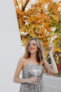 Kaboompics - Woman Touching Her Hair with Champagne beside a White Wall in Autumn