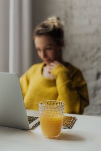Kaboompics - Soft Focus Portrait of Woman Thinking Behind Laptop and Orange Juice