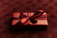 Kaboompics - Red Gift Box with Large Bow on Woven Fabric