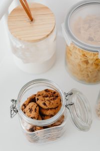 Kaboompics - Close-Up of a Wooden-Lidded Flour Jar beside an Open Farfalle Pasta Container